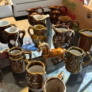 Collection of brown pitchers, little miniature houses, horse and shoes
